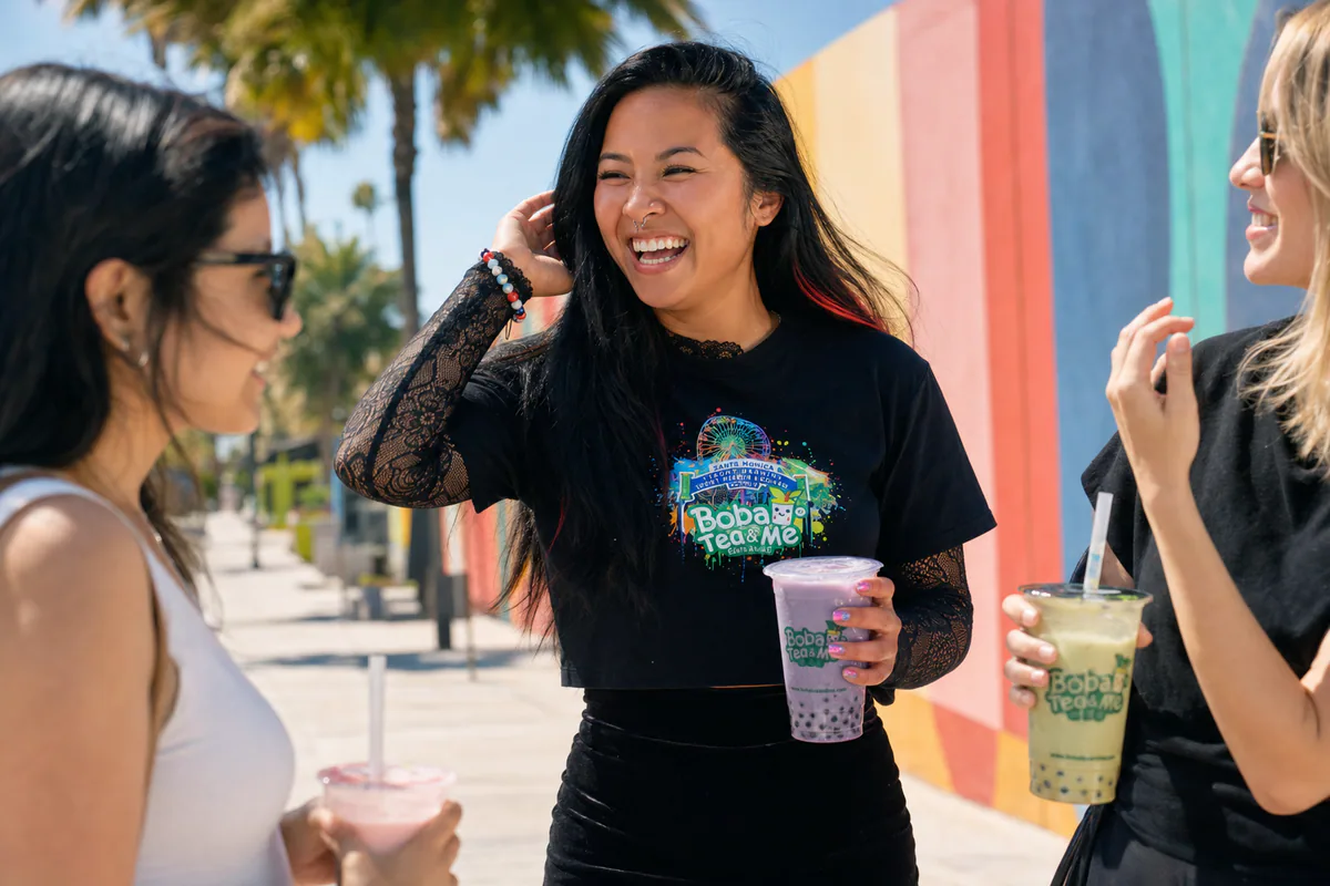 Three people holding Boba Tea and Me drinks in front of a colorful outdoor wall.